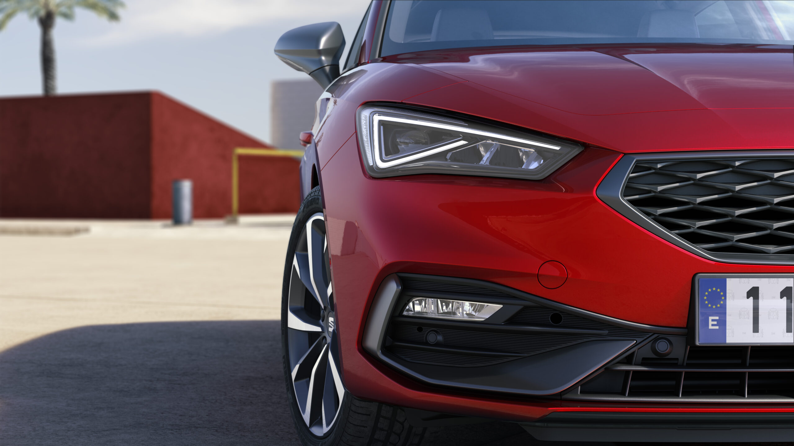 SEAT Leon czerwony zbliżenie na przedni reflektor i maskę od strony pasażera